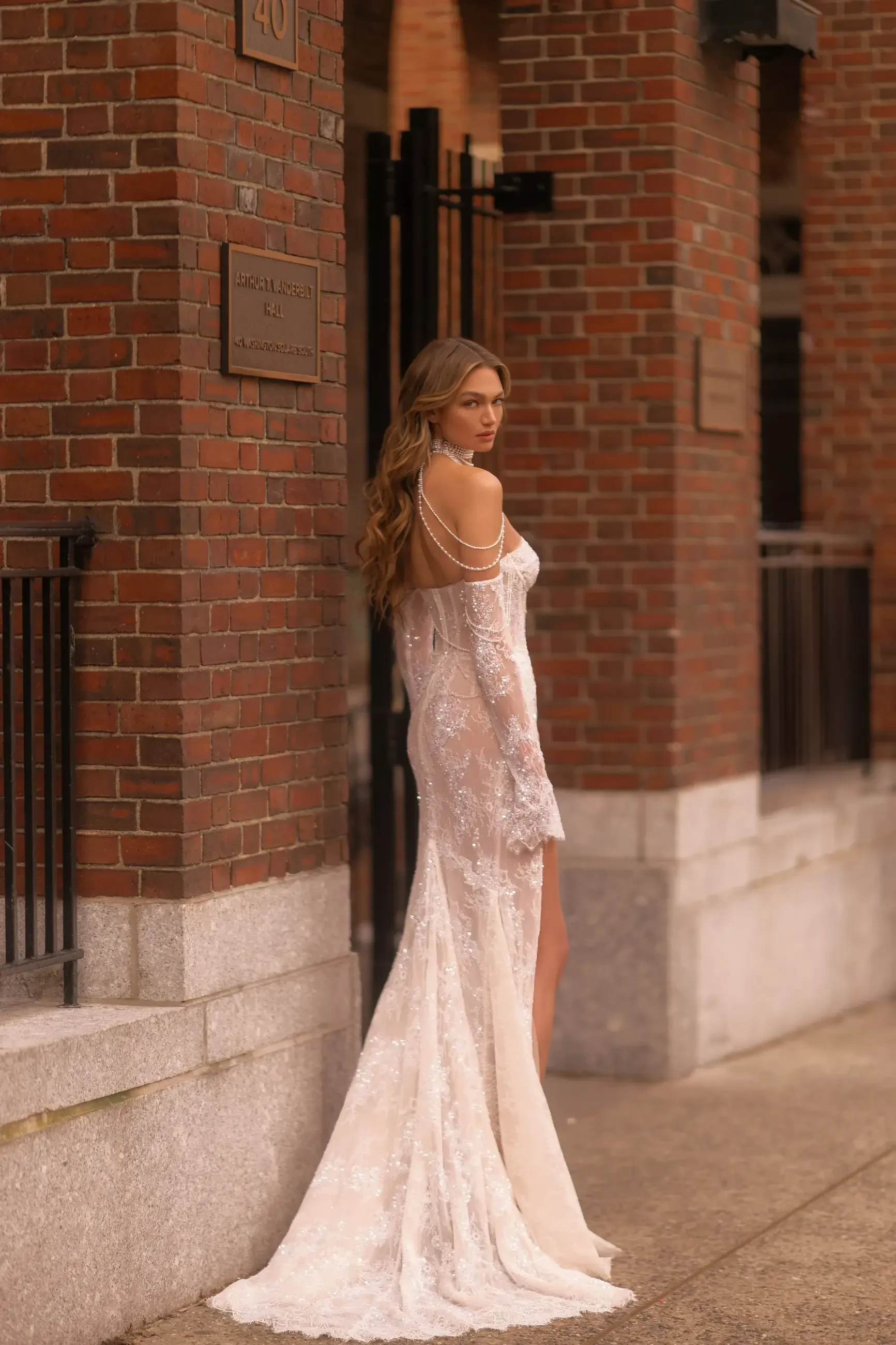 model is wearing a sheath lace off the shoulder wedding dress