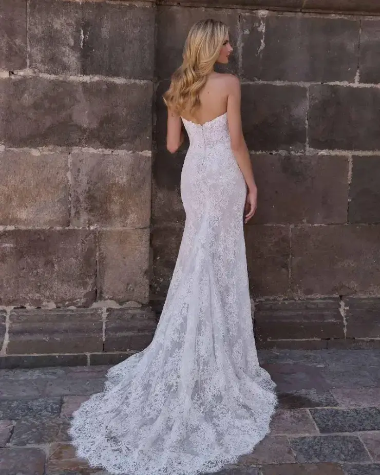 model is wearing a strapless lace fit and flare wedding dress