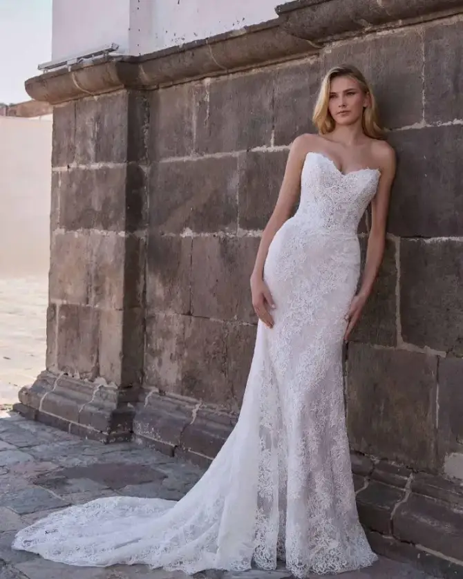 Model is wearing a strapless lace fit and flare bridal gown