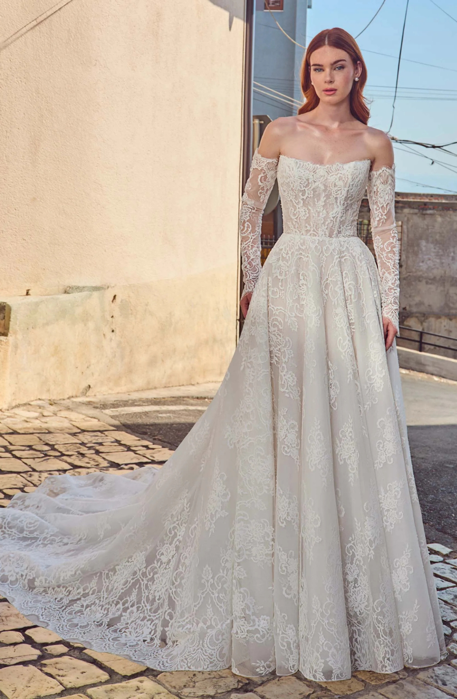 model is wearing an a-line wedding dress with detachable off the shoulder long lace sleeves