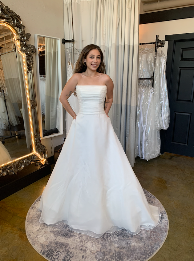 Model is wearing a strapless ball gown wedding dress 