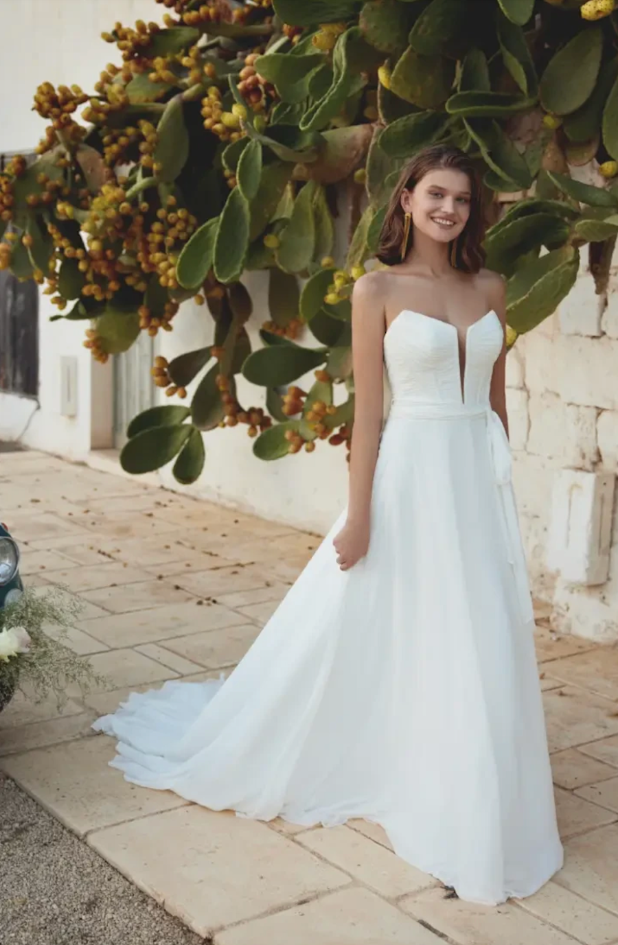 model is wearing a strapless a-line wedding dress