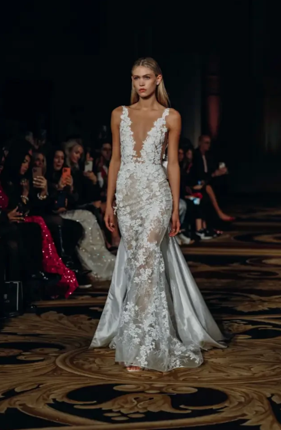 model is wearing a sleeveless floral lace bridal gown with a plunging neckline